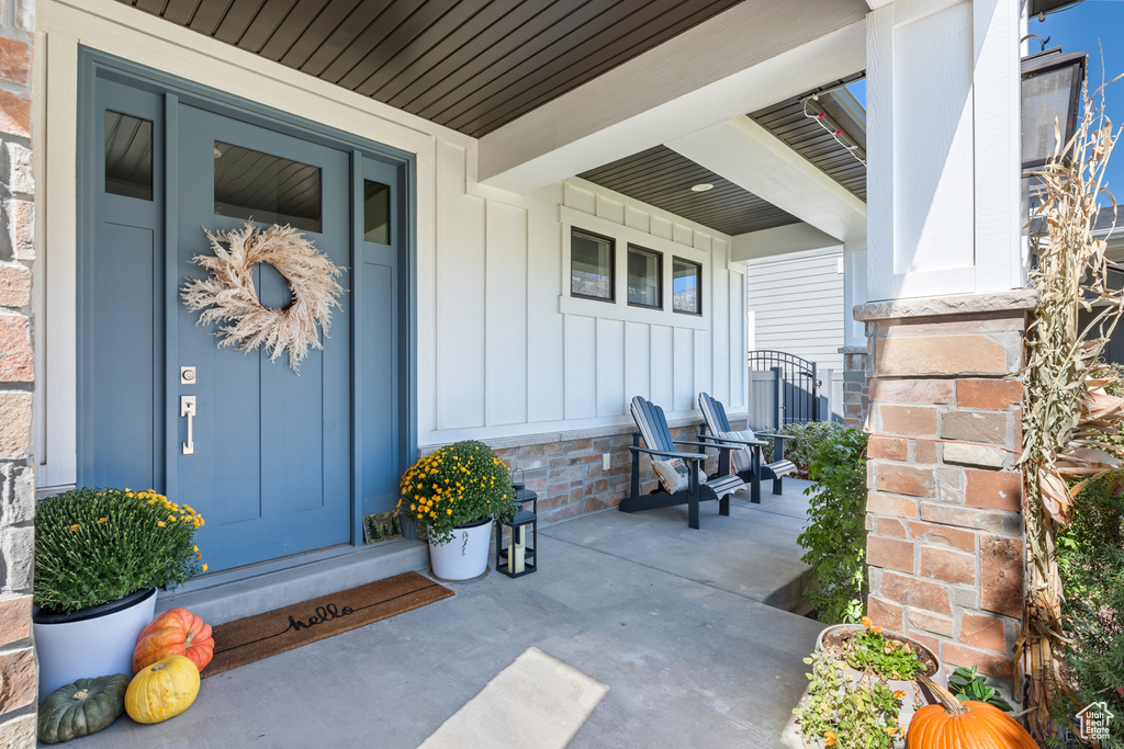 Doorway to property with a porch and board and batten siding