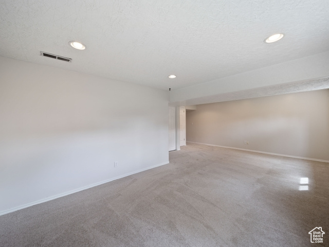 Unfurnished room with recessed lighting, a textured ceiling, visible vents, and baseboards