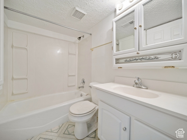 Bathroom with visible vents, toilet, vanity, shower / bathing tub combination, and a textured ceiling
