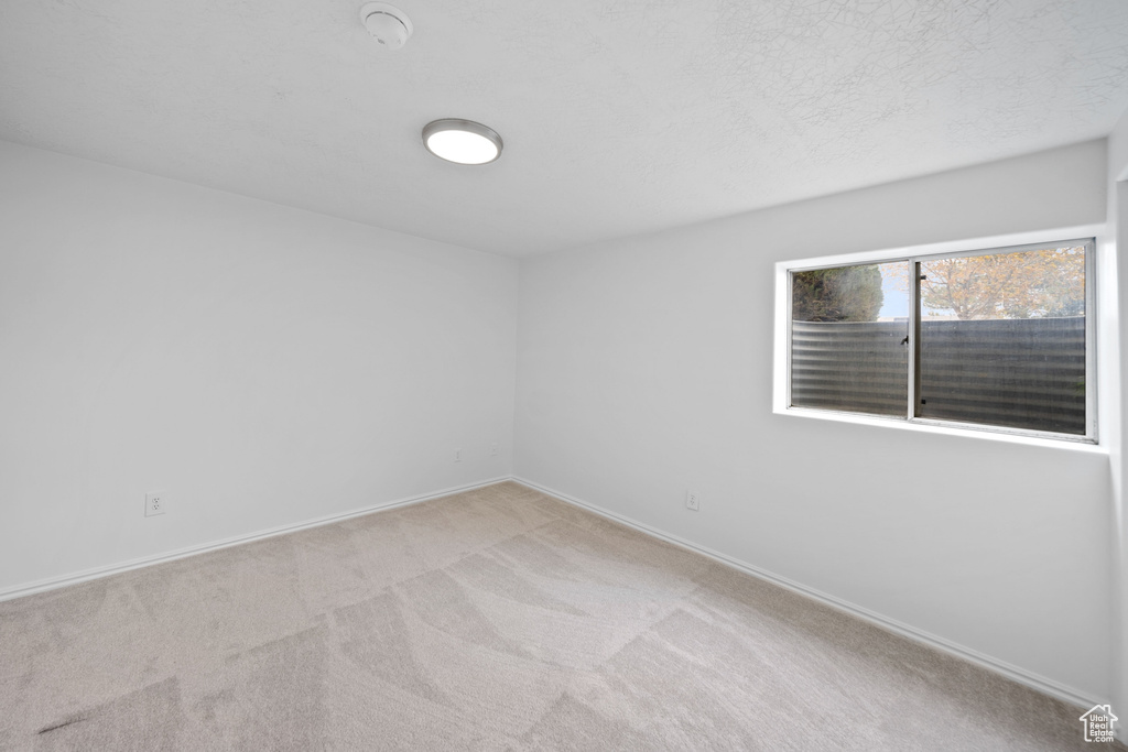 Unfurnished room with baseboards and carpet