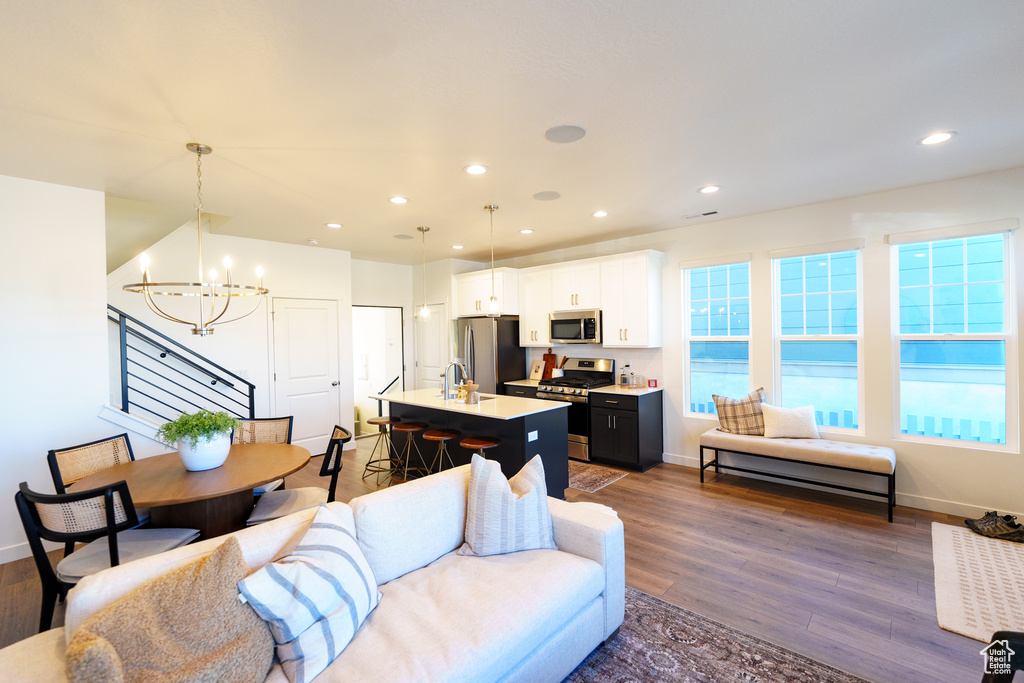 Living room featuring baseboards, an inviting chandelier, recessed lighting, and dark wood-style flooring