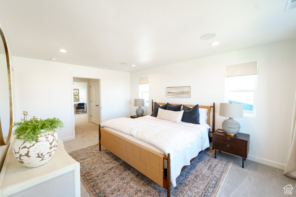 Bedroom with baseboards, light carpet, multiple windows, and recessed lighting