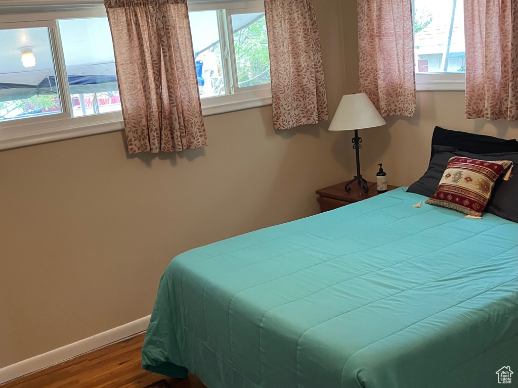 Bedroom featuring wood finished floors and baseboards
