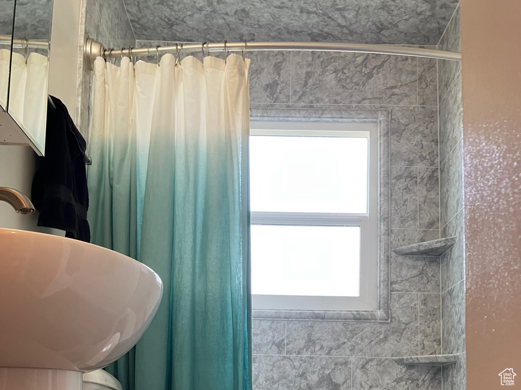 Bathroom featuring toilet, shower / tub combo, wood finished floors, and a sink