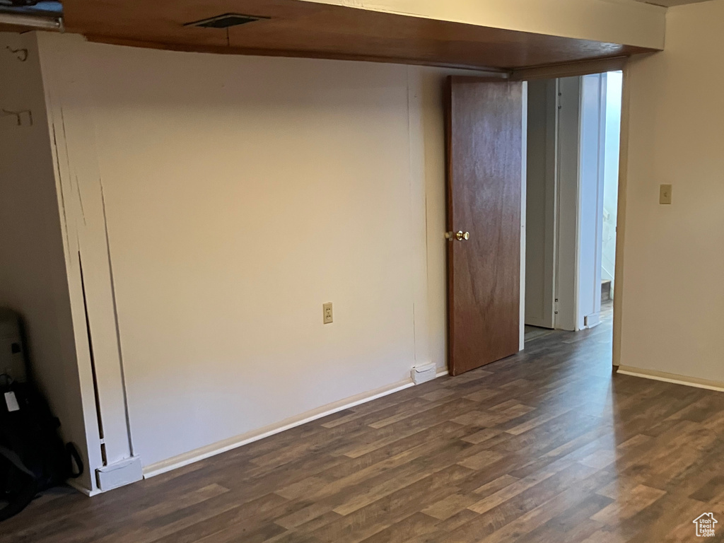 Unfurnished room with dark wood-style flooring