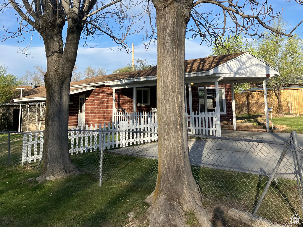 View of front facade with a porch, a fenced front yard, and brick siding