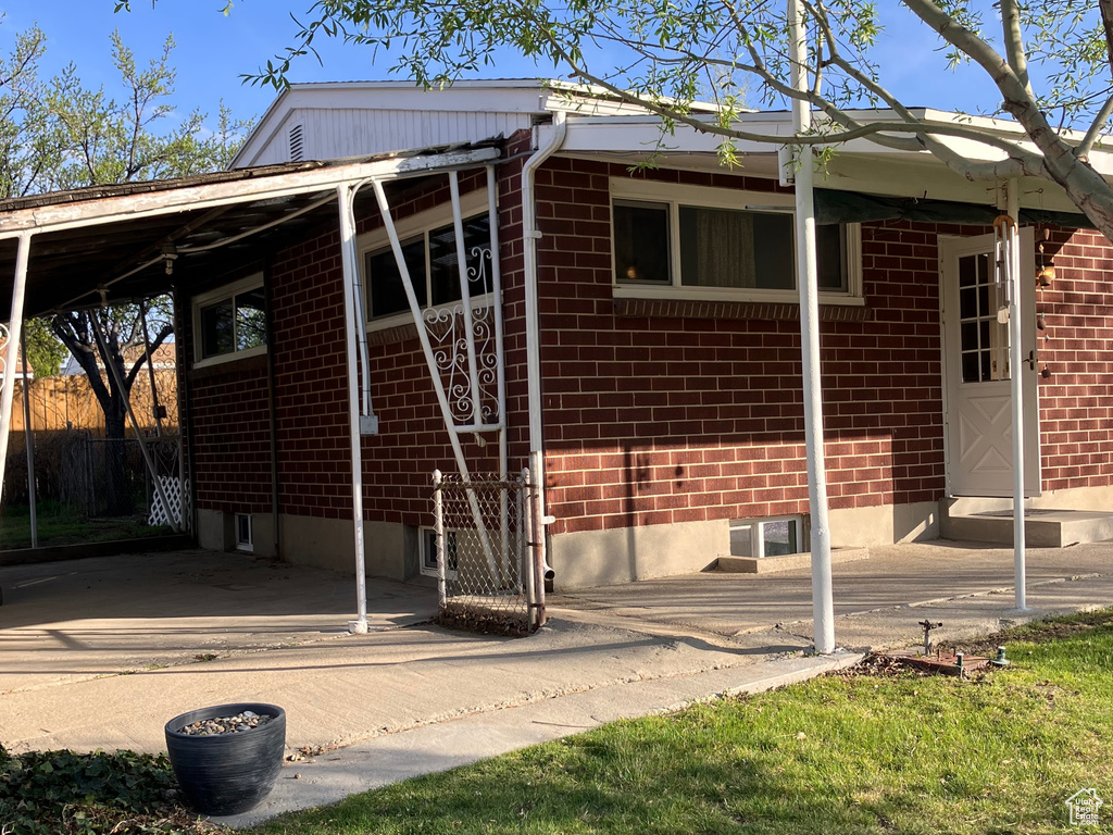 Rear view of property with brick siding and a yard