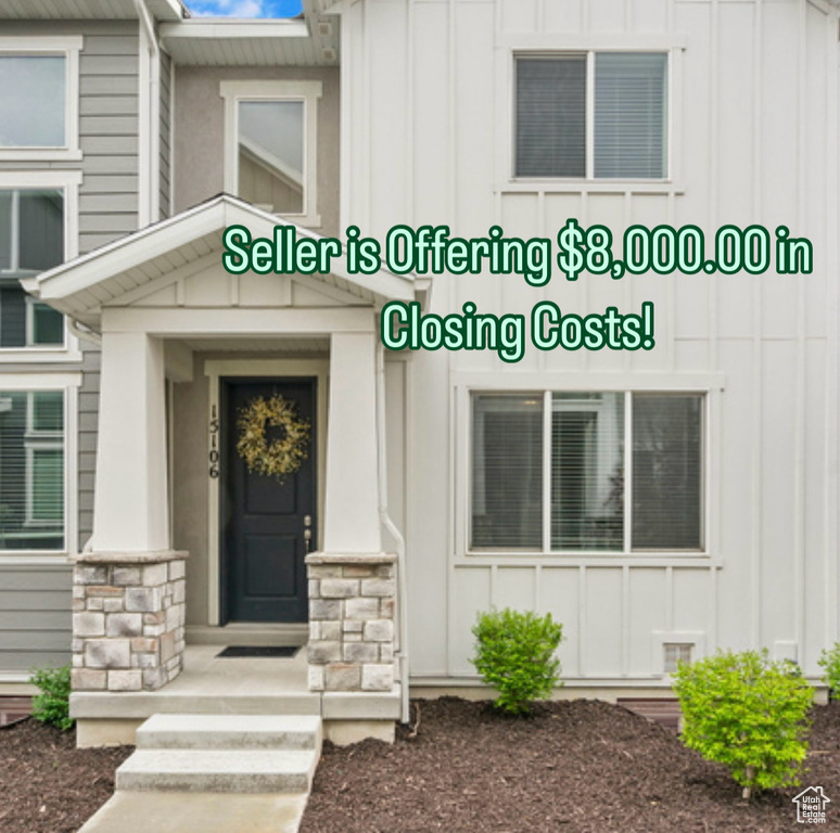 Entrance to property with board and batten siding and stone siding