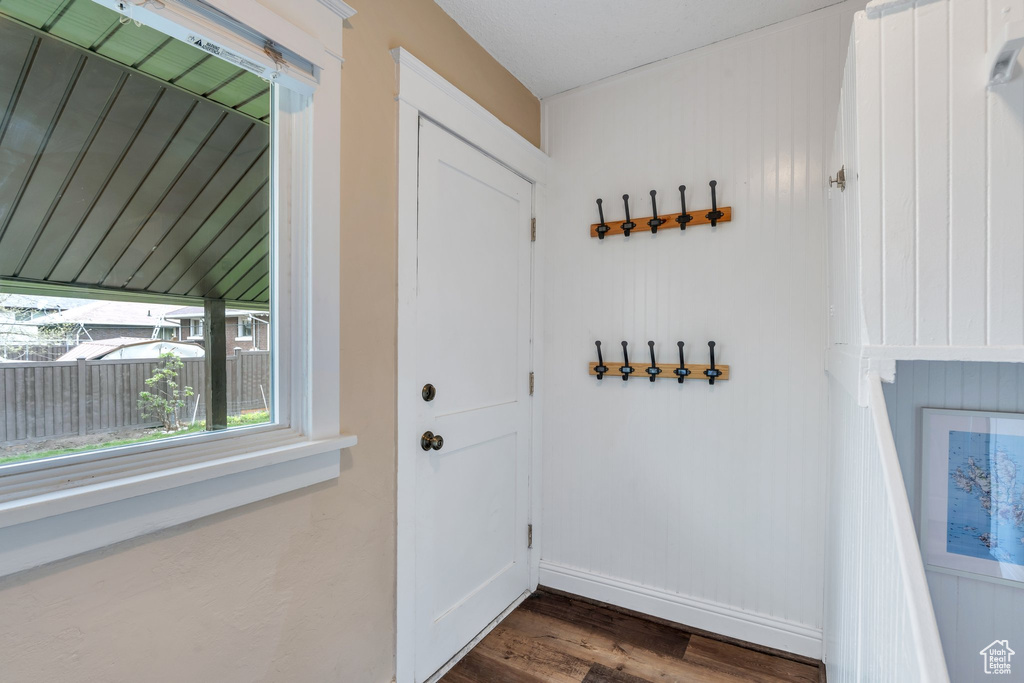Doorway with dark wood-style floors