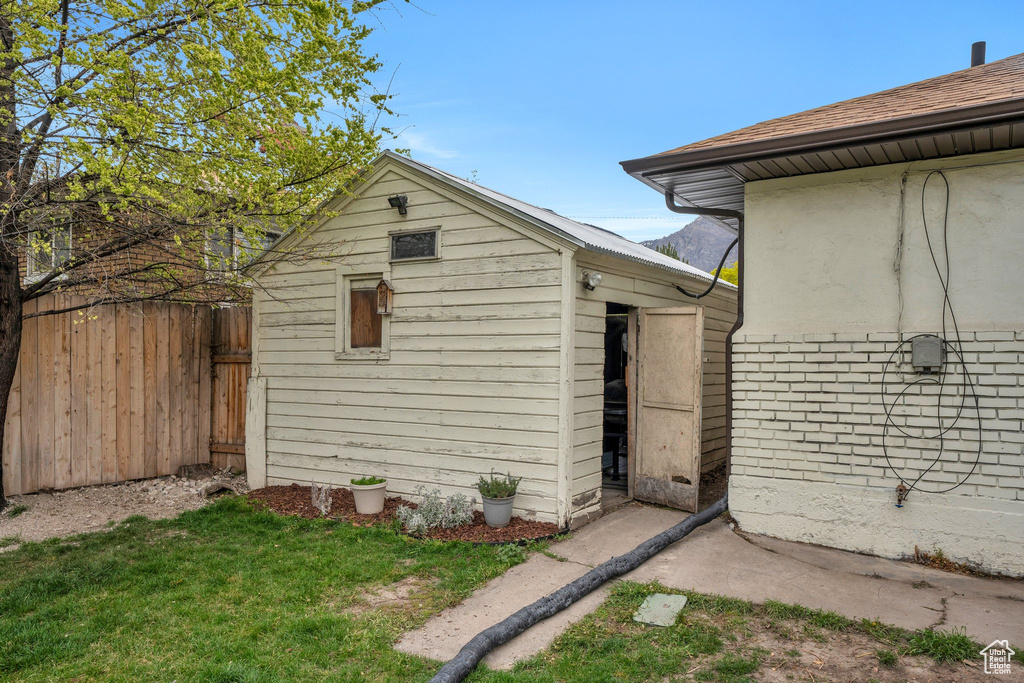 View of outbuilding with fence and an outbuilding