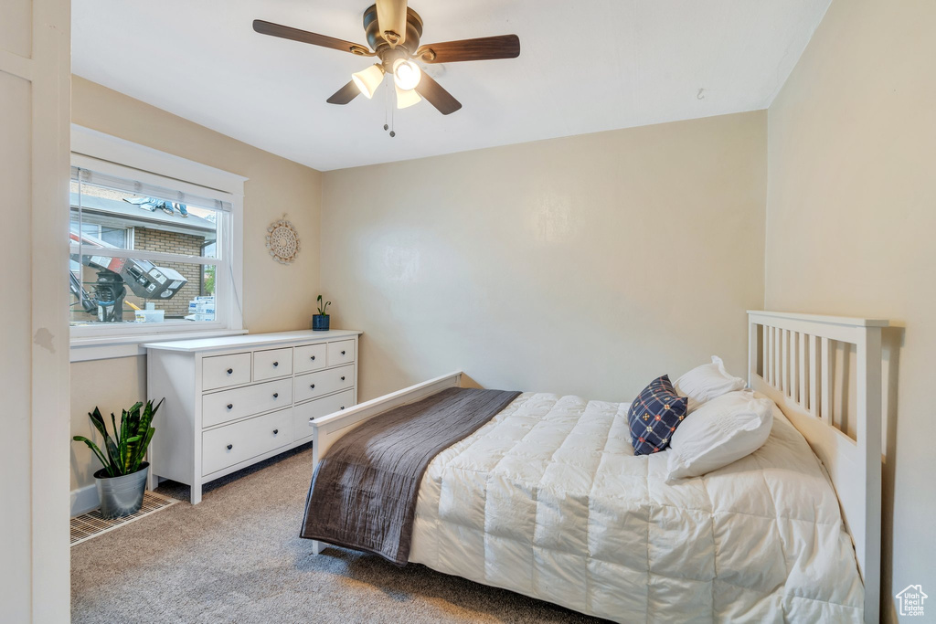 Carpeted bedroom featuring a ceiling fan and baseboards