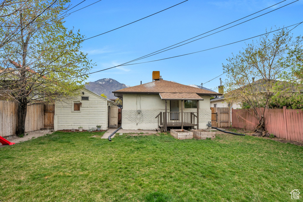 Rear view of property featuring brick siding, a yard, and a fenced backyard