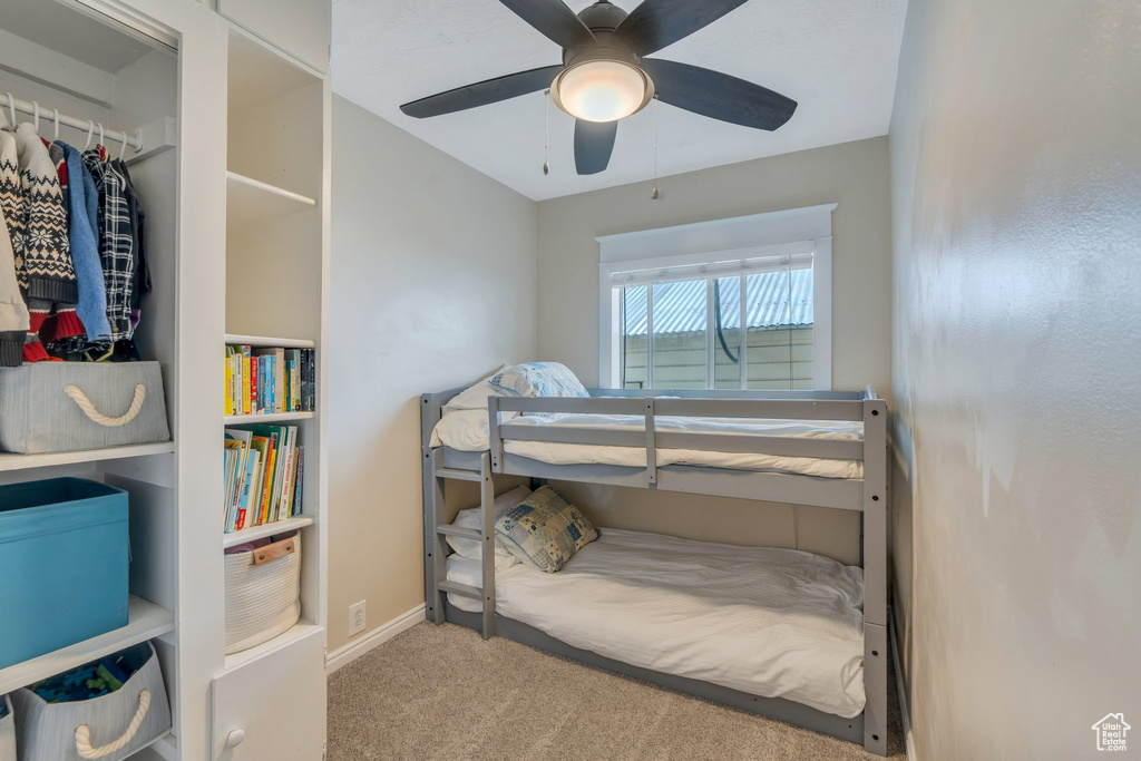 Carpeted bedroom featuring baseboards and ceiling fan