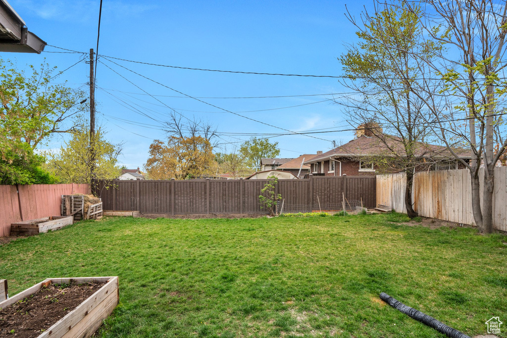 View of yard with a vegetable garden and a fenced backyard