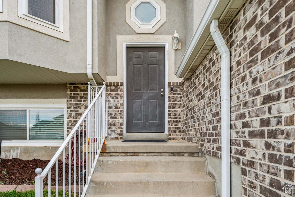 Doorway to property with brick siding and stucco siding