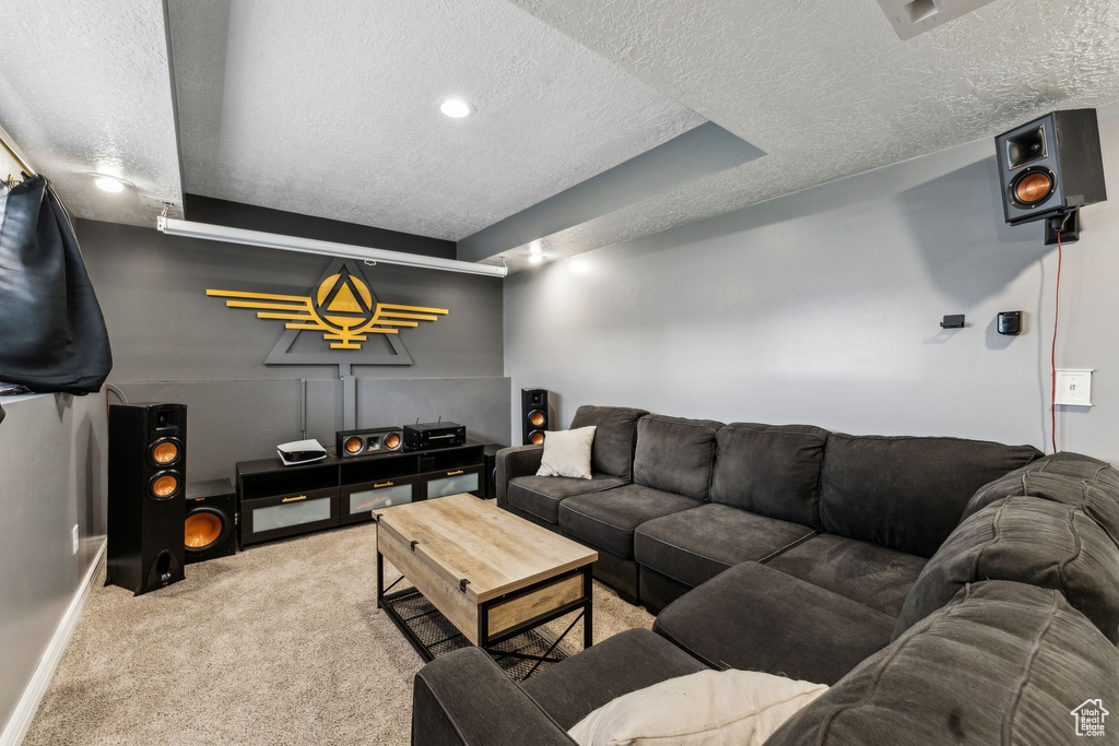 Carpeted living area featuring a textured ceiling and baseboards
