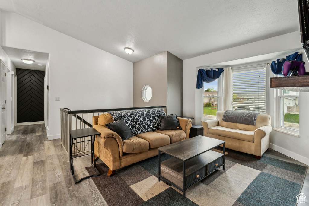 Living area featuring wood finished floors, baseboards, and plenty of natural light