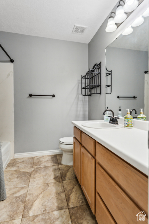 Bathroom with vanity, tub / shower combination, baseboards, toilet, and visible vents