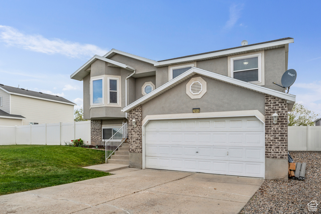 View of front of home featuring fence, a front lawn, stucco siding, and concrete driveway