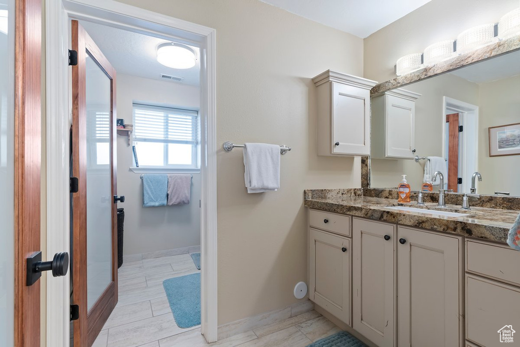 Bathroom featuring baseboards, visible vents, and vanity