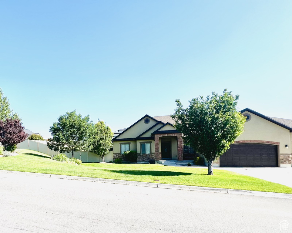 View of front of house featuring an attached garage, stucco siding, concrete driveway, stone siding, and roof mounted solar panels