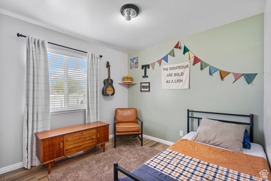Bedroom featuring wood finished floors and baseboards