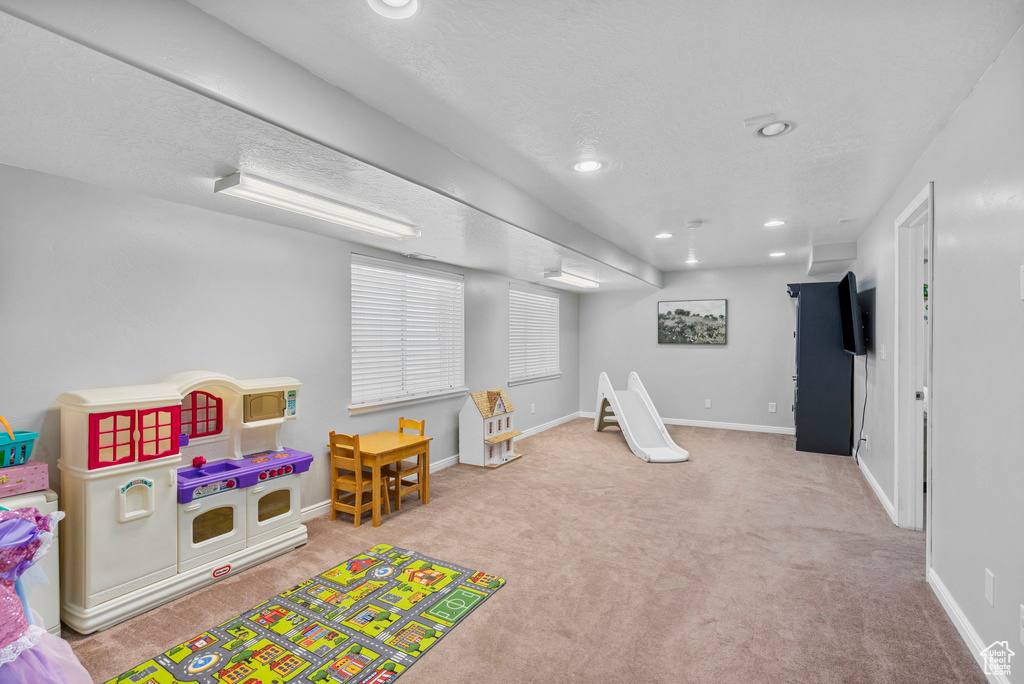 Recreation room featuring baseboards, carpet, and recessed lighting