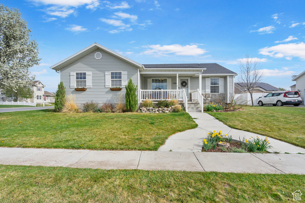 View of front of property featuring a front lawn and covered porch