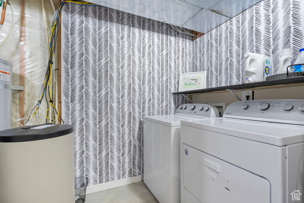 Laundry area featuring wallpapered walls, washing machine and clothes dryer, and laundry area