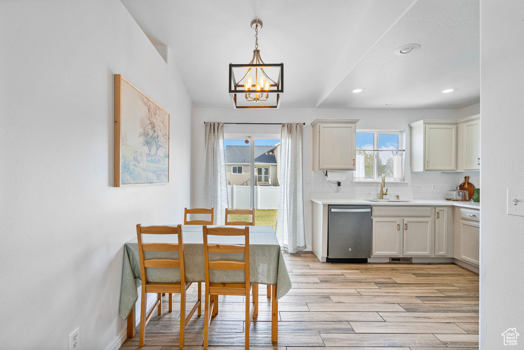 Kitchen featuring dishwasher, an inviting chandelier, a sink, and light wood finished floors