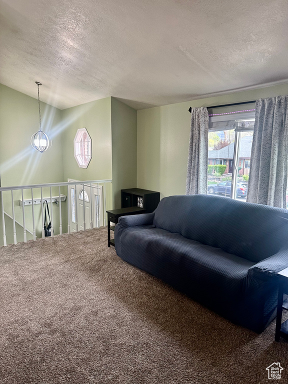 Carpeted living room with vaulted ceiling and a textured ceiling