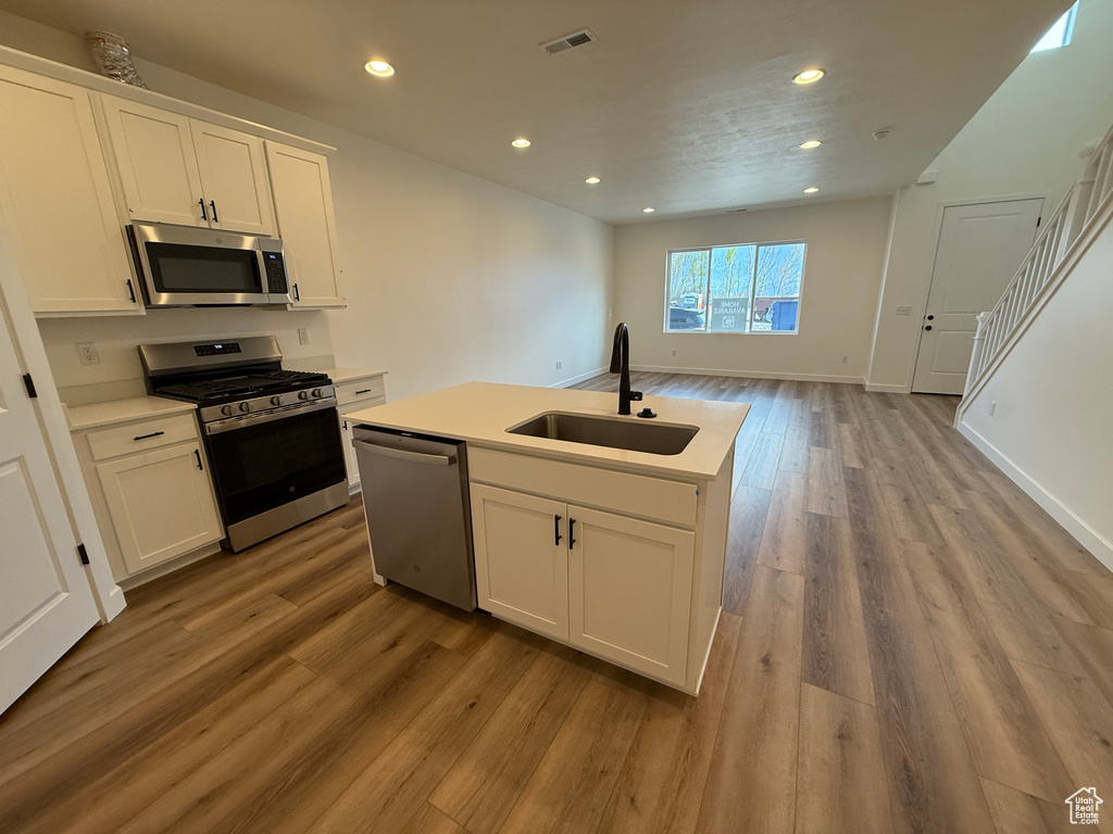 Kitchen featuring recessed lighting, light wood finished floors, stainless steel appliances, and a sink
