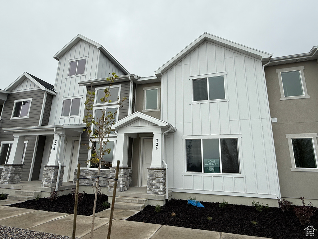 Townhome / multi-family property with board and batten siding and stone siding
