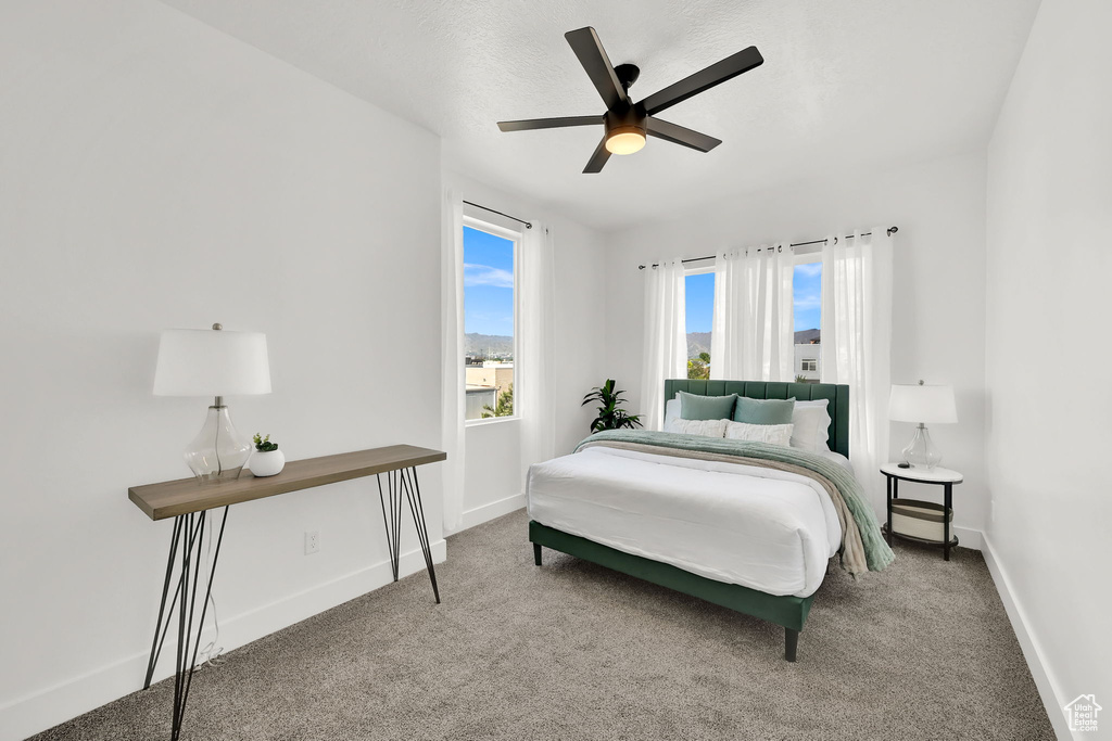 Carpeted bedroom featuring baseboards and a ceiling fan