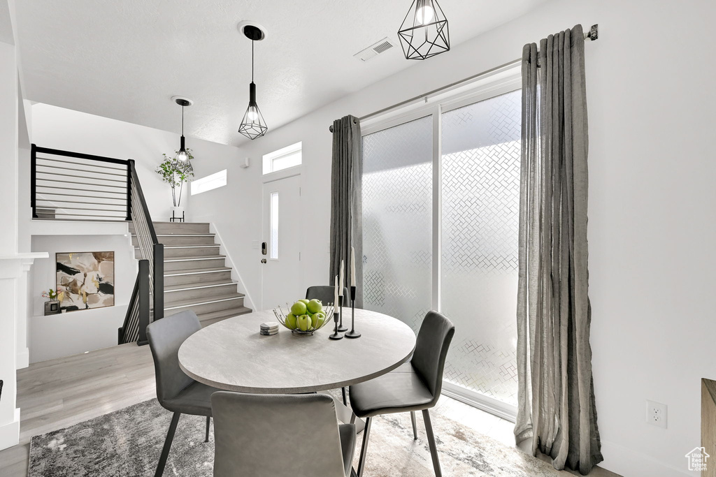 Dining space with stairway and wood finished floors