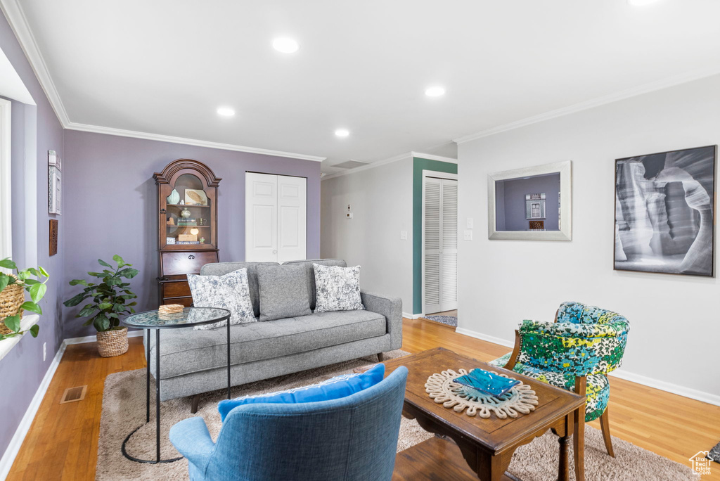 Living area featuring recessed lighting, wood finished floors, baseboards, and ornamental molding