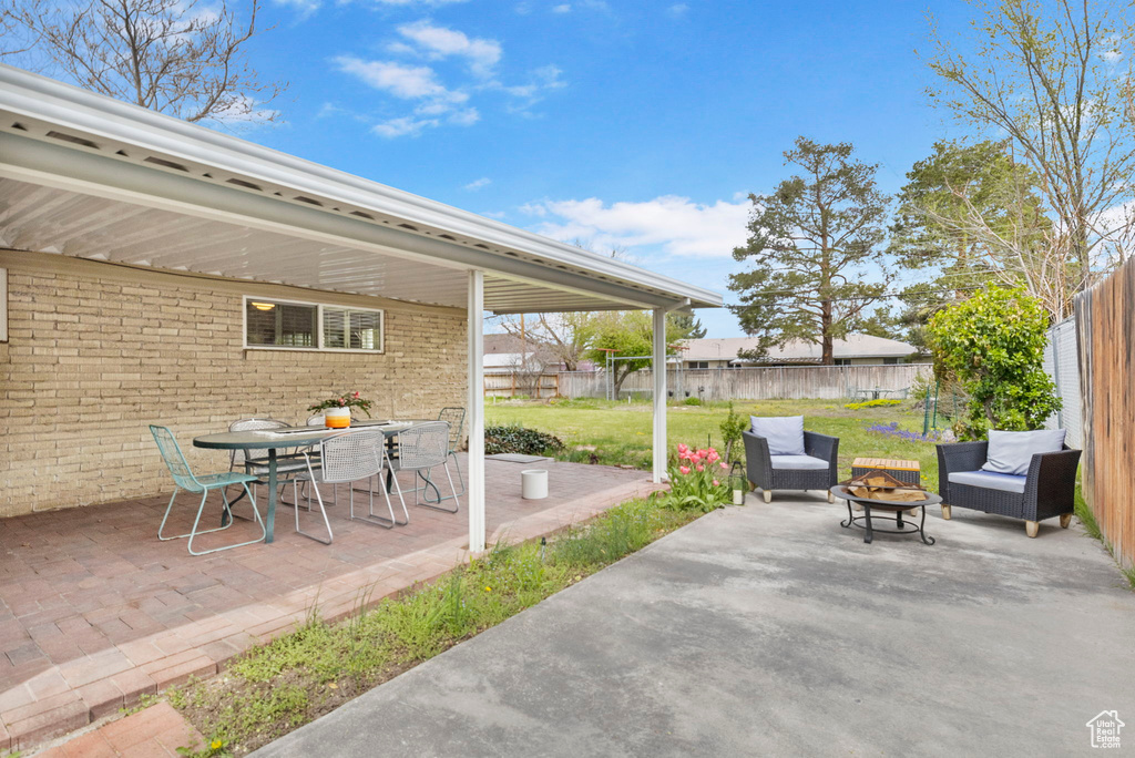 View of patio with a fire pit and a fenced backyard