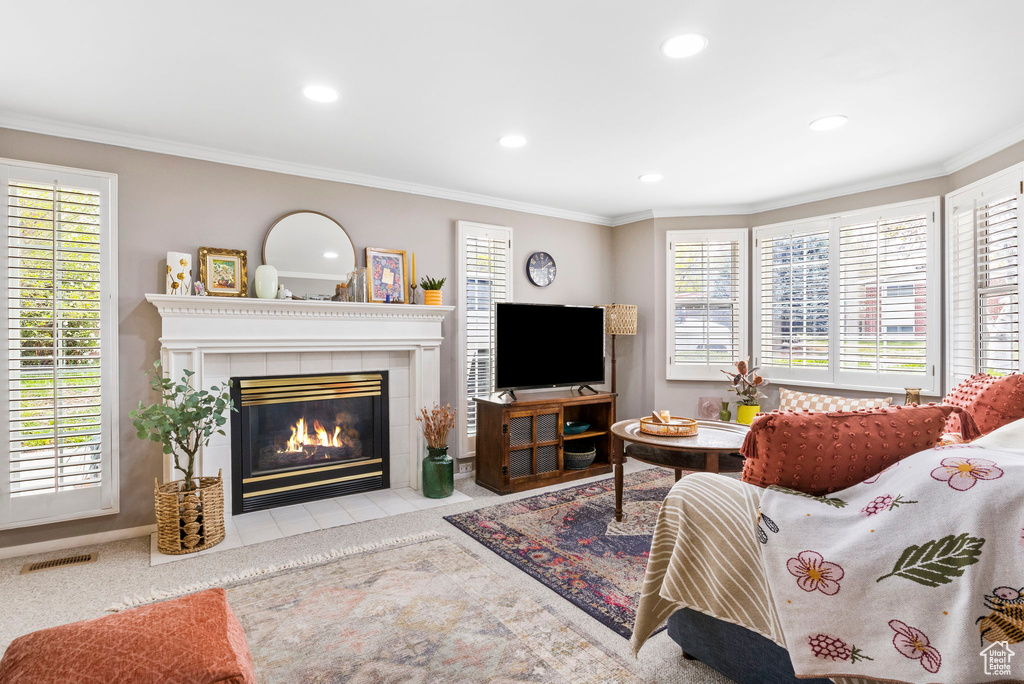 Living room with a wealth of natural light, a tiled fireplace, visible vents, and recessed lighting