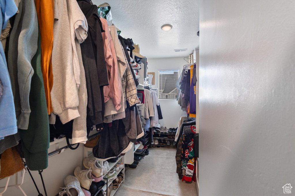 Walk in closet featuring visible vents and carpet floors