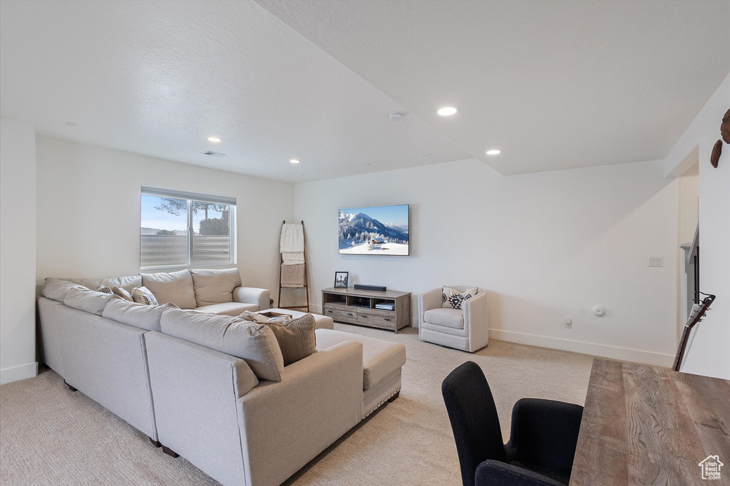 Living room featuring light carpet, baseboards, and recessed lighting