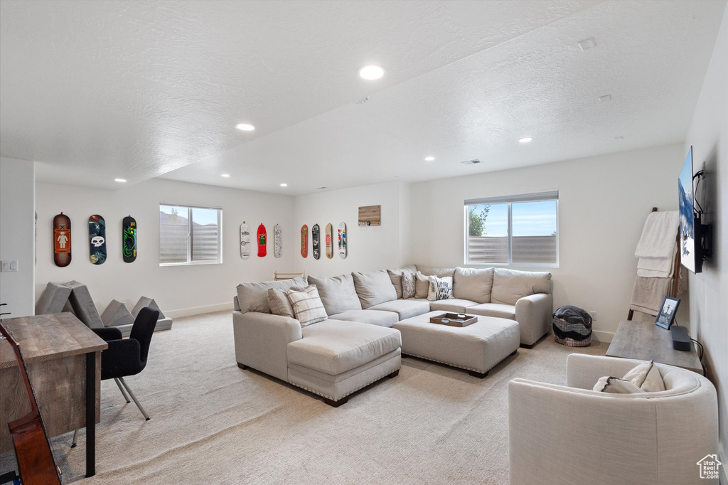 Living area featuring light colored carpet, baseboards, and recessed lighting