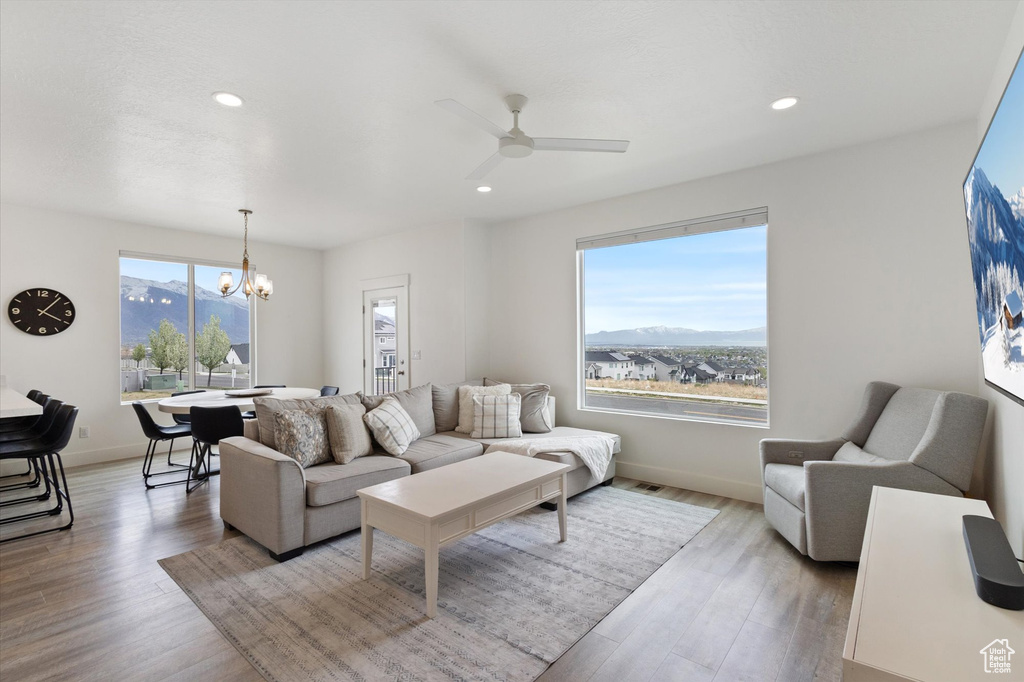 Living area featuring recessed lighting, wood finished floors, ceiling fan with notable chandelier, and a mountain view