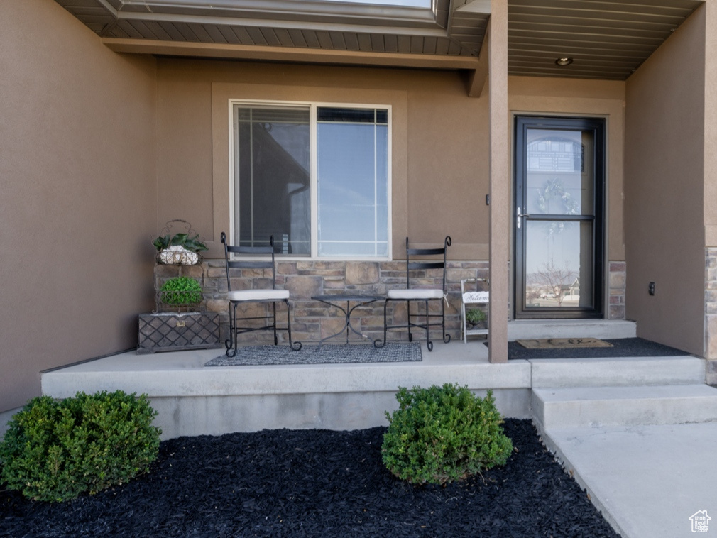 Entrance to property featuring stone siding and stucco siding