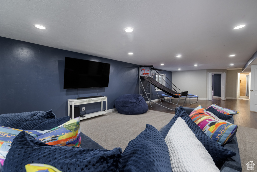Living area with wood finished floors, baseboards, and recessed lighting