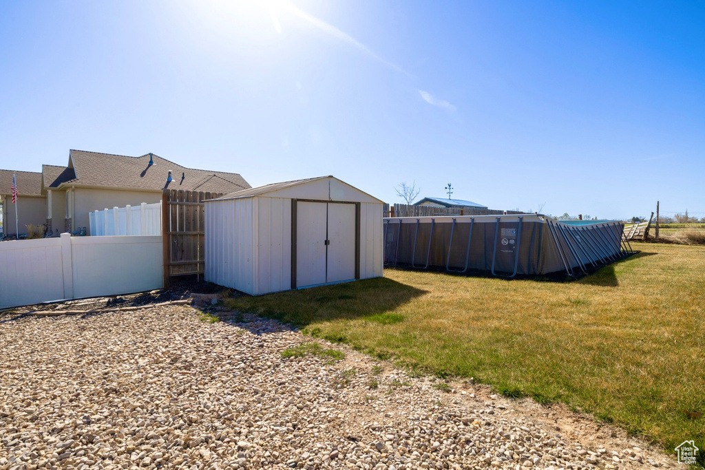View of yard featuring a fenced backyard, an outdoor structure, and a storage unit