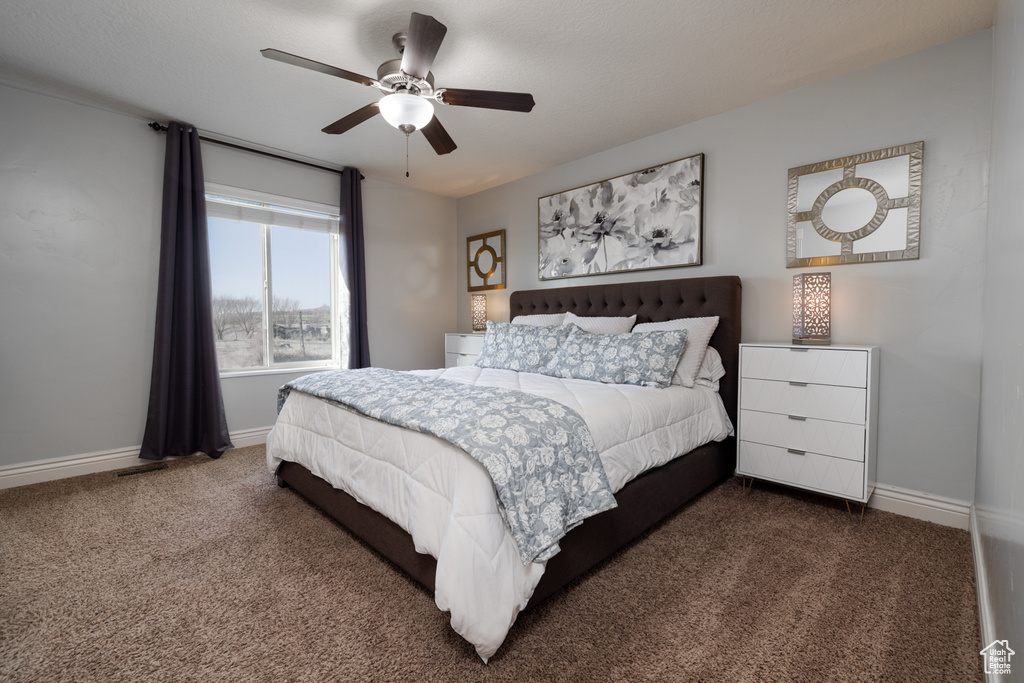 Bedroom with ceiling fan, baseboards, and carpet