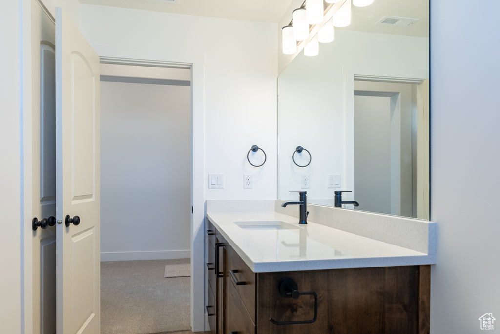 Bathroom with baseboards, visible vents, and vanity