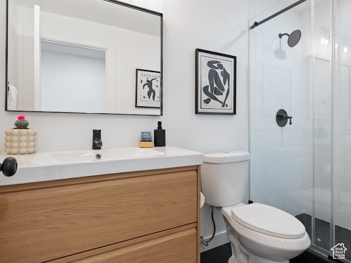 Bathroom with a shower stall, toilet, and vanity