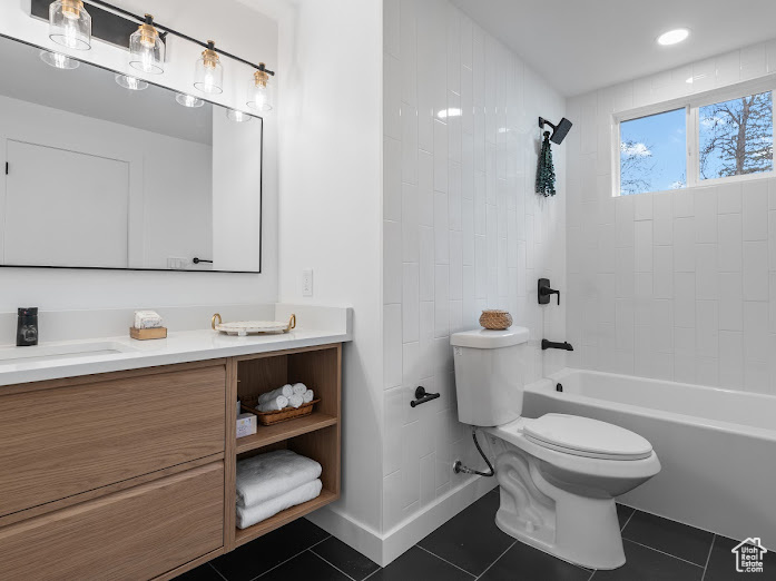 Bathroom with bathing tub / shower combination, vanity, tile patterned flooring, and toilet