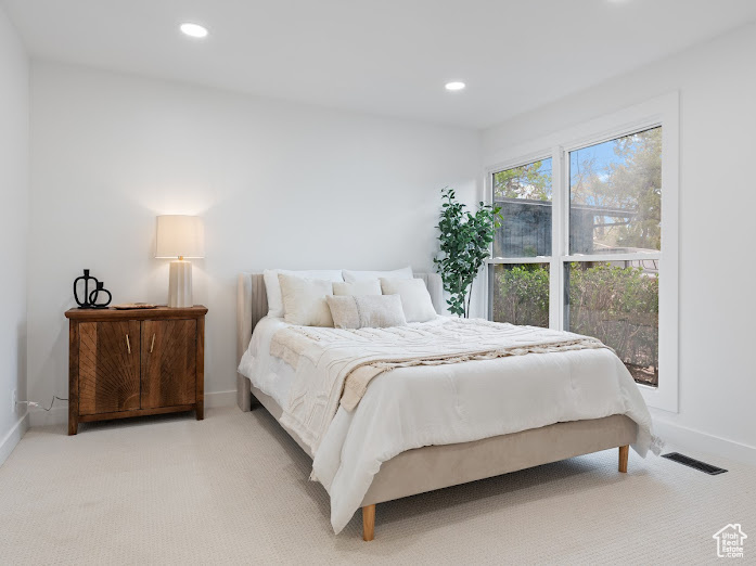 Bedroom with light colored carpet, baseboards, and recessed lighting